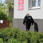 Policjant przed budynkiem szkoły - fot. Starostwo Powiatowe w Zgierzu