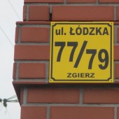 tabliczka z numerem porządkowym nieruchomości na ścianie budynku