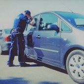 Policjant zagląda przez szybę do samochodu